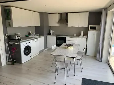 a kitchen with a table and chairs in a room at Clos du Cardinal avec piscine in LʼIsle-sur-la-Sorgue