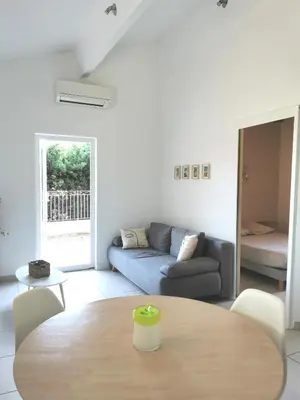 a living room with a table and a couch at Charmant T2 avec extérieur au cœur du Vaucluse in Châteauneuf-de-Gadagne