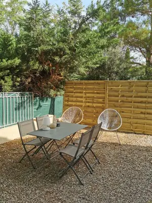 a table and four chairs sitting next to a fence at Charmant T2 avec extérieur au cœur du Vaucluse in Châteauneuf-de-Gadagne