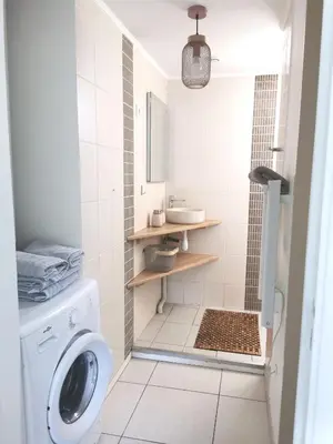 a bathroom with a washing machine and a sink at Charmant T2 avec extérieur au cœur du Vaucluse in Châteauneuf-de-Gadagne