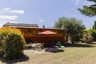a food trailer with a table and an umbrella at Roulotte chez Manon en Luberon in Lagnes