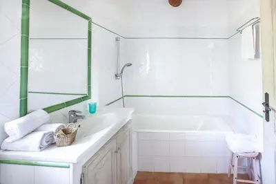 a white bathroom with a tub and a sink at Gîte St Roch en Luberon in Castellet