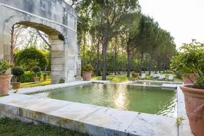 a large pool of water in a park with trees at Chateau Talaud in Loriol-du-Comtat