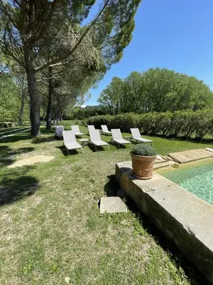 a row of white lounge chairs next to a pool at Chateau Talaud in Loriol-du-Comtat