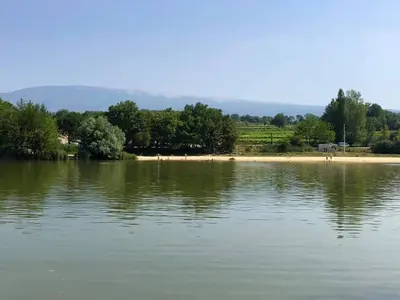 a large body of water with trees and a beach at Mas Boudeissoun - Cœur de cerise - Baignade à 600 m in Mormoiron
