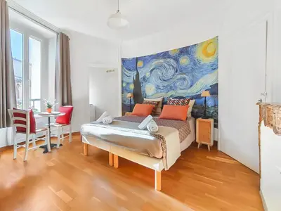 a bedroom with a bed and a painting on the wall at L'Isle d'Or - La Nuit Etoilée in LʼIsle-sur-la-Sorgue