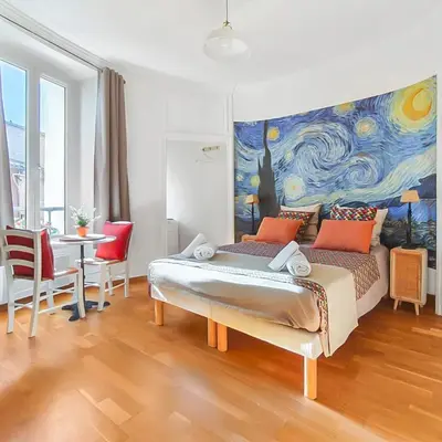 a bedroom with a bed and a painting on the wall at L'Isle d'Or - La Nuit Etoilée in LʼIsle-sur-la-Sorgue