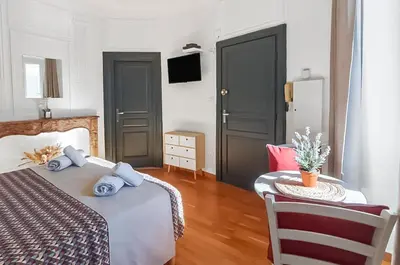 a bedroom with a bed and a table with a chair at L'Isle d'Or - La Nuit Etoilée in LʼIsle-sur-la-Sorgue