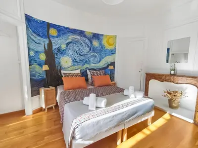 a bedroom with a bed with a painting on the wall at L'Isle d'Or - La Nuit Etoilée in LʼIsle-sur-la-Sorgue