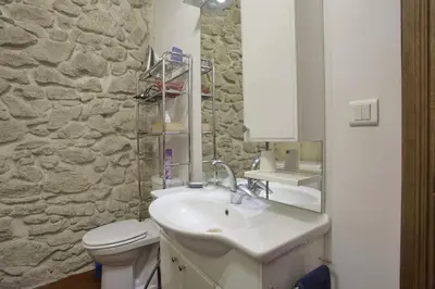 a bathroom with a sink and a toilet and a stone wall at La Mauricette - free Parking & Cancellation - WiFi in Pélissanne