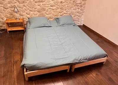a large bed in a room with a table at La Mauricette - free Parking & Cancellation - WiFi in Pélissanne