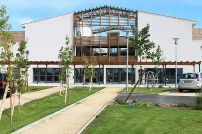 a large white building with a playground in front of it at 107 Paisible et unique avec terrasse sur vue piscine in Éguilles