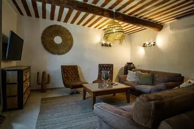 a living room with a couch and a table at Mas Sylvie - Isle-sur-la-Sorgue in LʼIsle-sur-la-Sorgue
