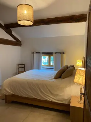 a bedroom with a large bed and a window at Mas Sylvie - Isle-sur-la-Sorgue in LʼIsle-sur-la-Sorgue