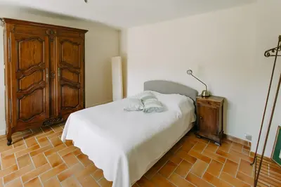 a bedroom with a bed and a wooden cabinet at Villa Balleti - private pool with a view in Apt