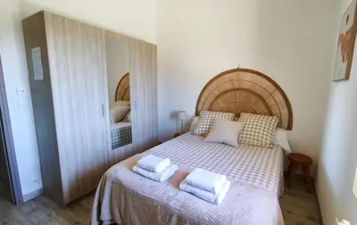 a bedroom with a bed with two towels on it at Appartement de Charme L'Isle-sur-la-Sorgue sur la Sorgues in LʼIsle-sur-la-Sorgue