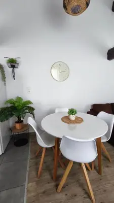 a kitchen with a table and chairs and a clock on the wall at Appartement de Charme L'Isle-sur-la-Sorgue sur la Sorgues in LʼIsle-sur-la-Sorgue