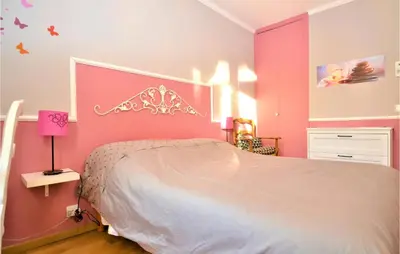 a bedroom with a large bed with pink walls at Gorgeous Home In Eyragues in Eyragues