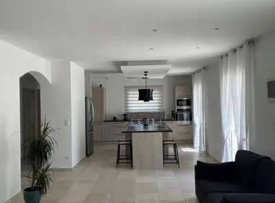 a kitchen and living room with a couch and a table at La Bastide Cezanne Natural elegance in Aix-en-Provence