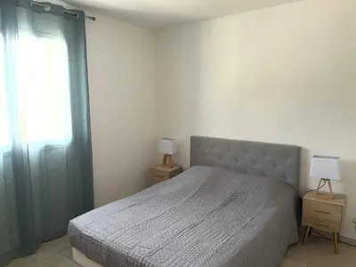 a bedroom with a bed and a window and two lamps at La Bastide Cezanne Natural elegance in Aix-en-Provence