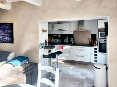 a kitchen with white cabinets and a bar stool at Appartement spacieux à Aix-en-Provence 100 m² avec hammam in Aix-en-Provence