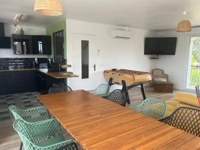 a living room with a wooden table and chairs at Haut de villa avec piscine privée et extérieur in Lançon-Provence