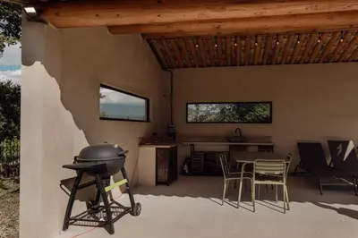 a patio with a grill and a table and chairs at L'Olivier in Mormoiron