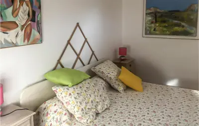 a bed with green and yellow pillows in a bedroom at 3 Bedroom Cozy Home In Meyrargues in Meyrargues