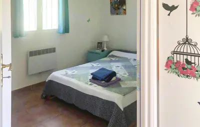 a small bedroom with a bed with a blue blanket at 3 Bedroom Cozy Home In Meyrargues in Meyrargues