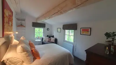 a bedroom with a bed with white sheets and windows at Lou Pantai, House, 5 bedrooms, 8 people, AC, Pool, Large garden,4km from AIX EN PROVENCE in Aix-en-Provence