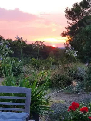 a bench in a garden with the sunset in the background at Lou Pantai, House, 5 bedrooms, 8 people, AC, Pool, Large garden,4km from AIX EN PROVENCE in Aix-en-Provence