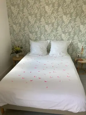 a bed with white sheets and pink flowers on it at La Manuia in Ventabren