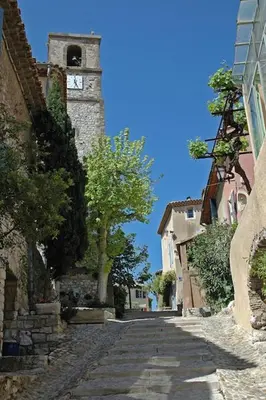 a cobblestone street with a clock tower in a town at La Manuia in Ventabren