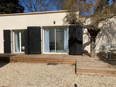 a house with black doors and a wooden deck at La Manuia in Ventabren