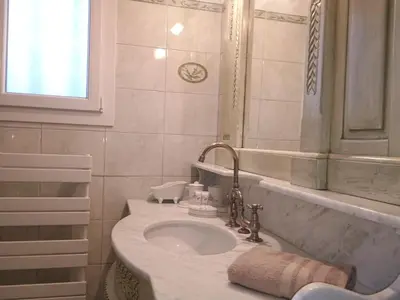 a white bathroom with a sink and a mirror at La Villa des Sorgues in LʼIsle-sur-la-Sorgue
