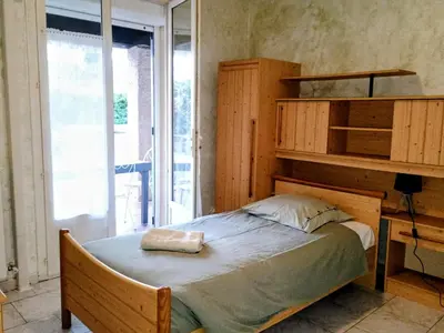 a bedroom with a bed and a large window at La Villa des Sorgues in LʼIsle-sur-la-Sorgue