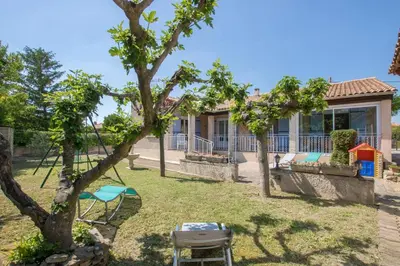 a house with a yard with a table and chairs at La Villa des Sorgues in LʼIsle-sur-la-Sorgue