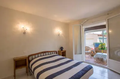 a bedroom with a striped bed and a large window at La Villa des Sorgues in LʼIsle-sur-la-Sorgue
