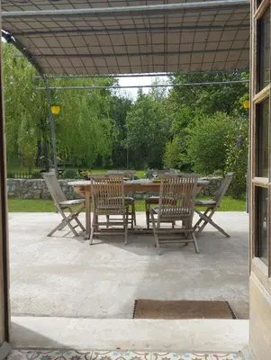 a patio with a table and chairs in a yard at Charmante bergerie dans un cadre bucolique in Saint-Rémy-de-Provence