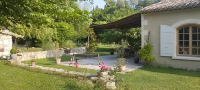 a garden with a bench and flowers in a yard at Charmante bergerie dans un cadre bucolique in Saint-Rémy-de-Provence