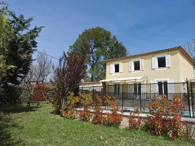 a house with a fence in front of a yard at Studio indépendant à 2 minutes du golf du Luberon in Pierrevert
