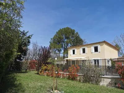 a house with a fence in front of a yard at Studio indépendant à 2 minutes du golf du Luberon in Pierrevert