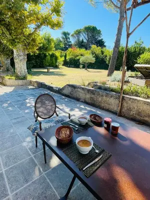 a picnic table with bowls of food on a patio at Le Mas des Perrines Maison d’Hôtes in Pernes-les-Fontaines