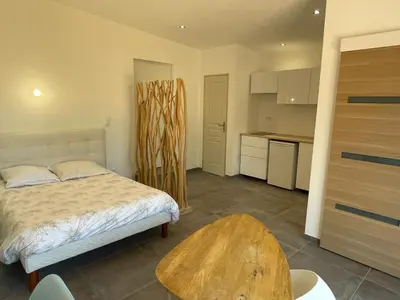 a bedroom with a bed and a wooden table at Beau studio en duo au coeur du Luberon in Saumane-de-Vaucluse