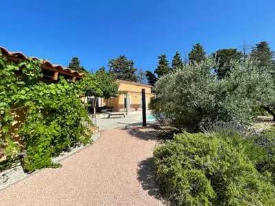 a garden with bushes and trees and a building at Beau studio en duo au coeur du Luberon in Saumane-de-Vaucluse
