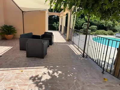 a patio with furniture next to a swimming pool at Beau studio en duo au coeur du Luberon in Saumane-de-Vaucluse
