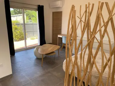 a room with a bed and a table and a chair at Beau studio en duo au coeur du Luberon in Saumane-de-Vaucluse