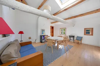 a living room with a couch and a table at APPARTEMENT DERNIER ETAGE DANS BASTIDE in Aix-en-Provence