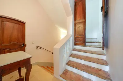 a staircase in a house with a wooden door at APPARTEMENT DERNIER ETAGE DANS BASTIDE in Aix-en-Provence