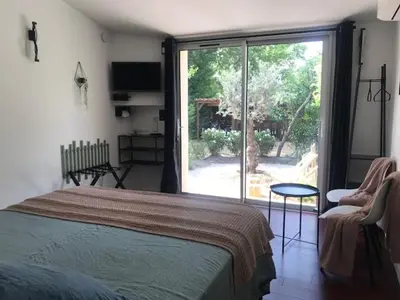 a bedroom with a bed and a sliding glass door at La Maison 1440 in LʼIsle-sur-la-Sorgue